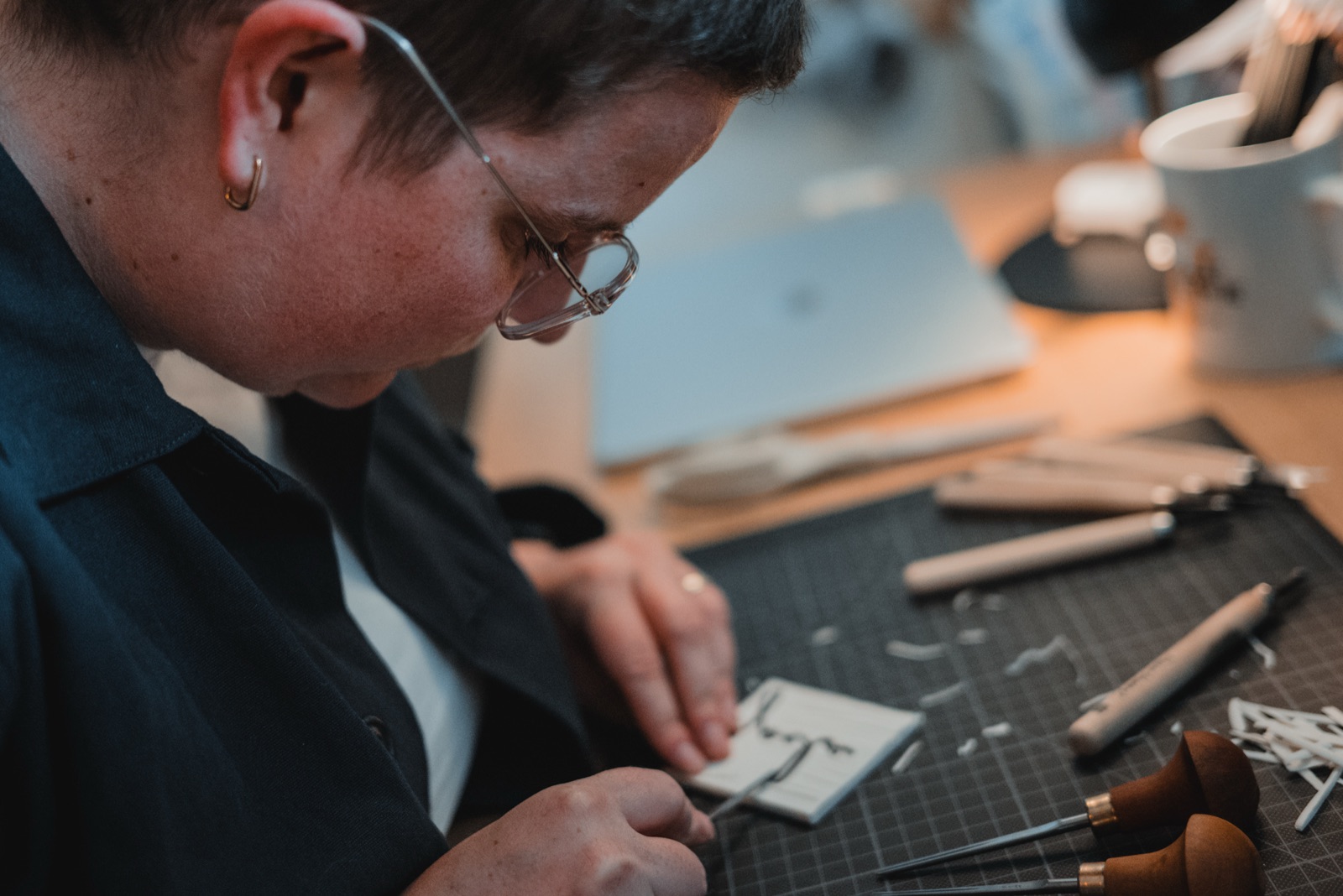 Maker van joele snijdt een linoblokje op de snijmat